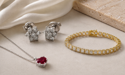 Jewelry set featuring a silver necklace with a red gemstone pendant, diamond cluster stud earrings, and a gold tennis bracelet