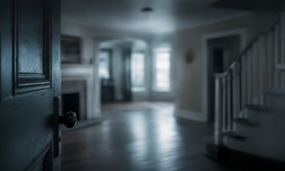 Open door reveals blurred, dimly lit interior.